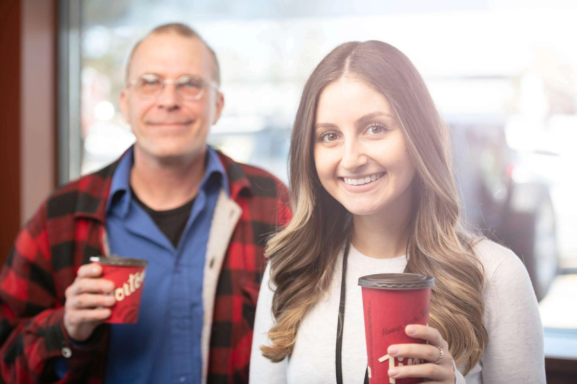One counselor holds a coffee cup while a client stands in the background. © robert lowdon