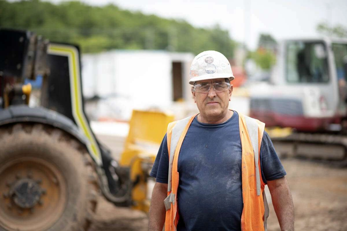 A worker walks around large machinery. © robert lowdon