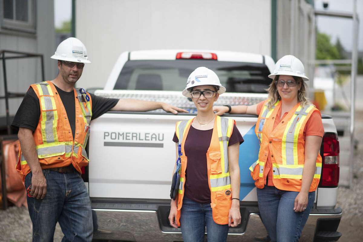 Management team pose in front of vehicle. © robert lowdon