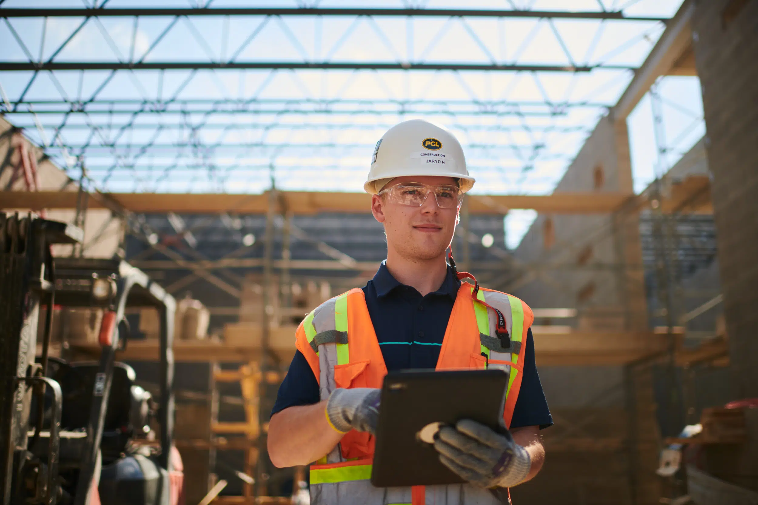 The construction worker is using a tablet on site for inspections. By using a tablet for inspections, the worker can save time and make the inspection process more efficient.
