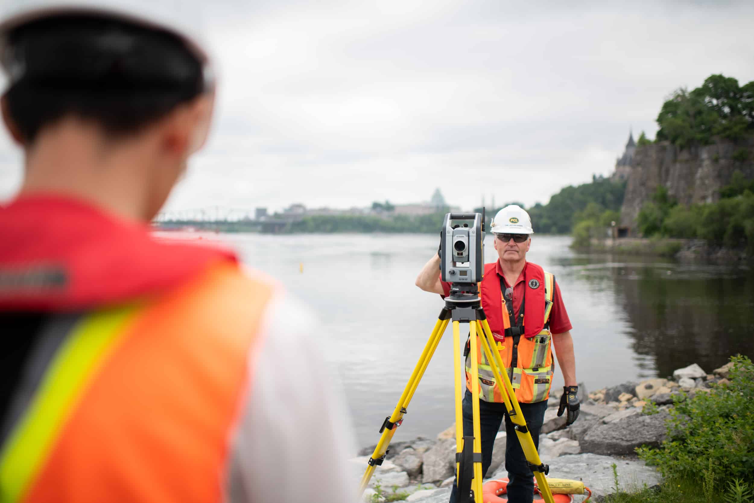 The surveyor maps the river bank, noting the location of trees, rocks, and other obstructions.