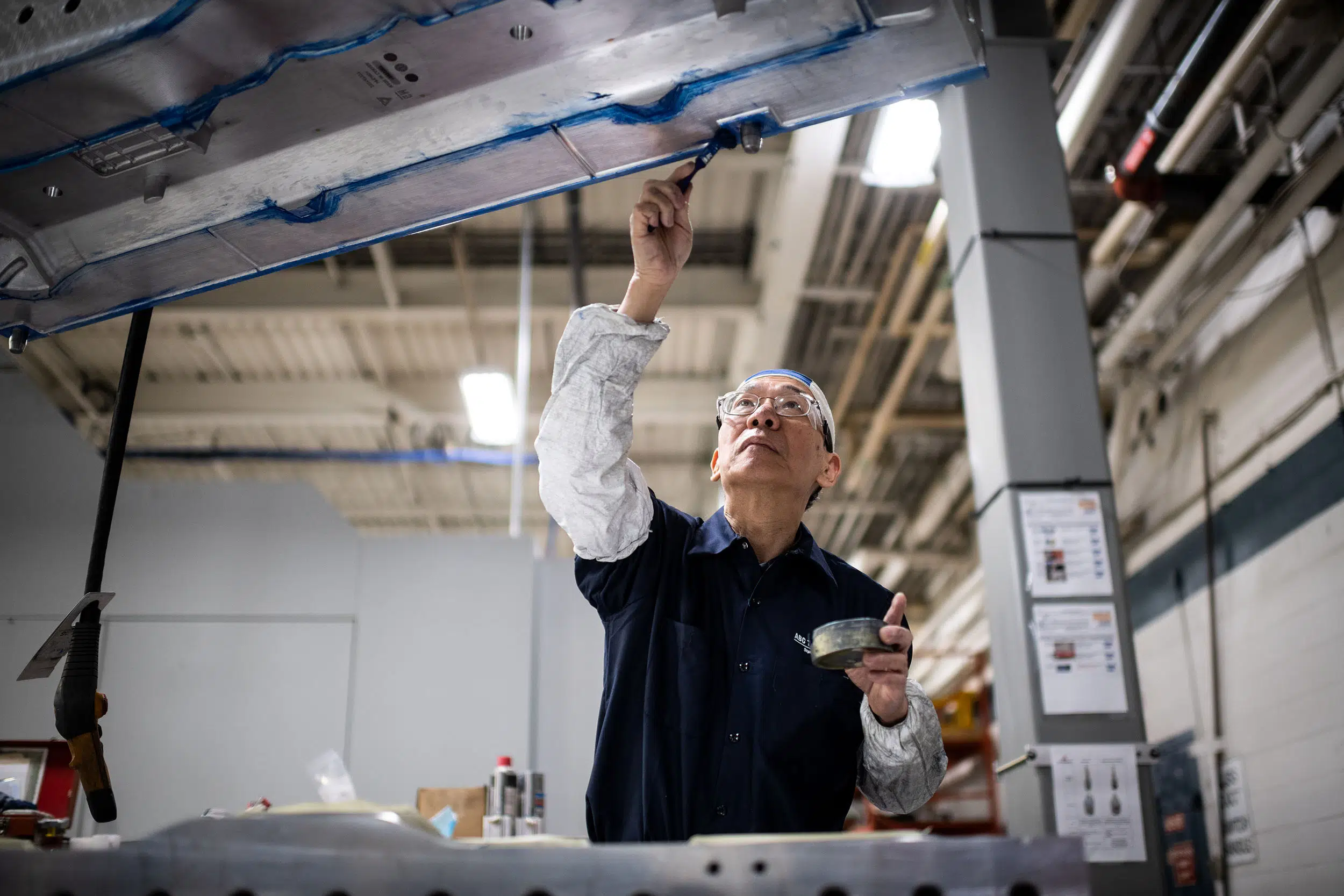 A worker applies grease to a new mold prior to production.