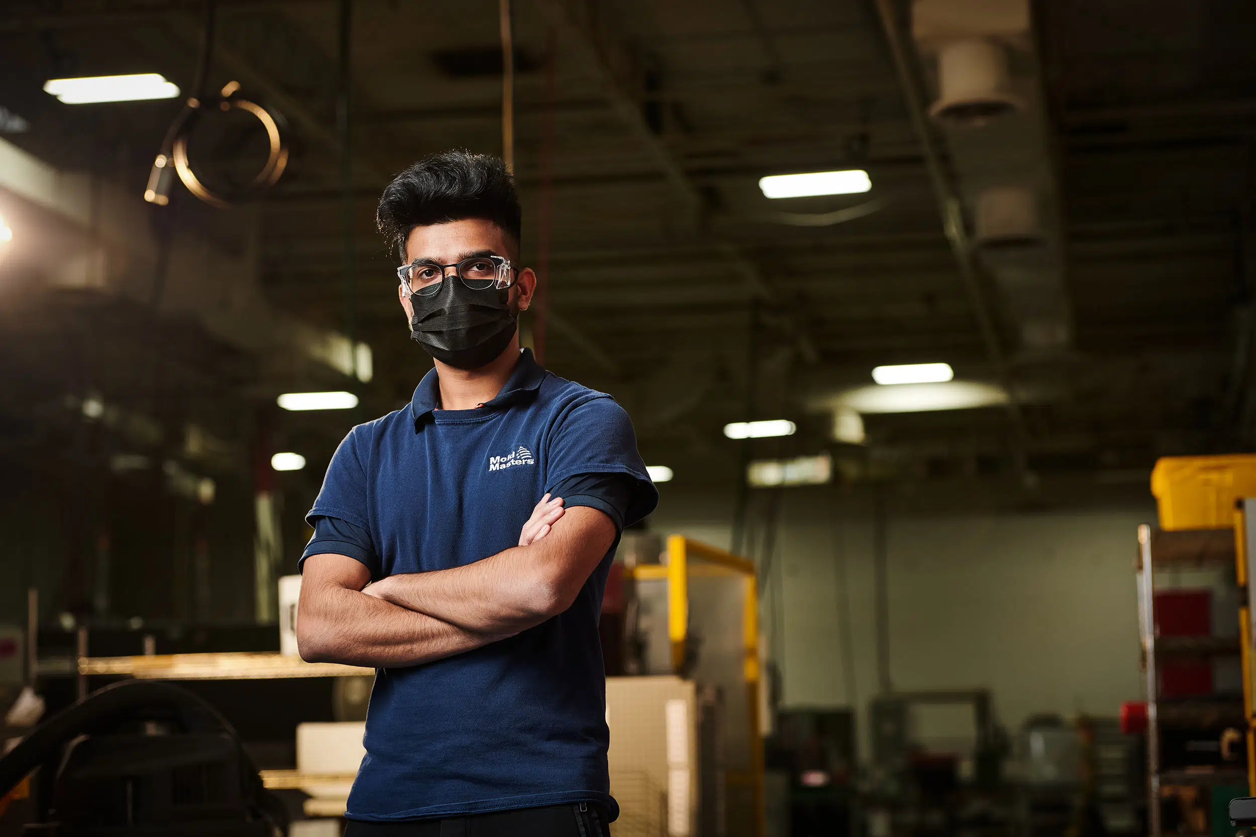 A worker crosses his arms for an image on the factory floor.