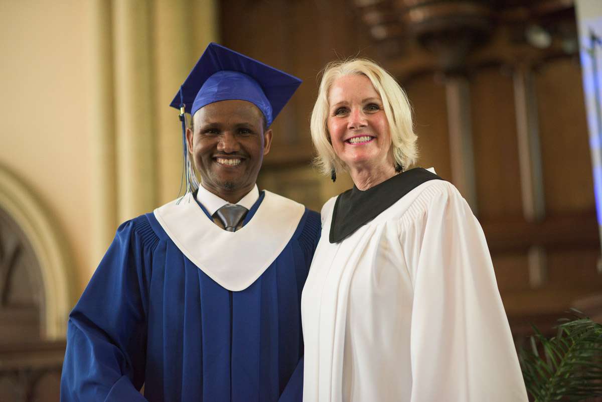 In this medium close-up, a student and instructor pose, smiling for the camera.