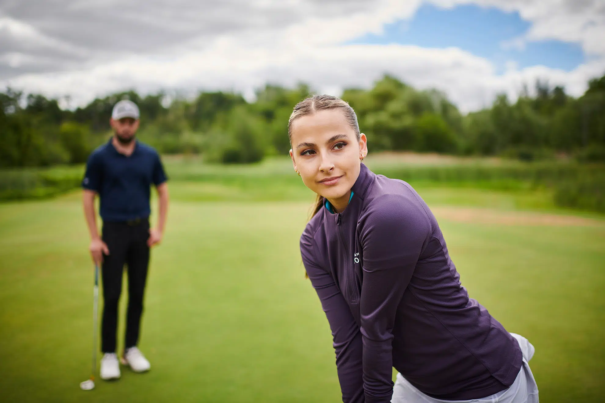 A female golfer prepares to putt