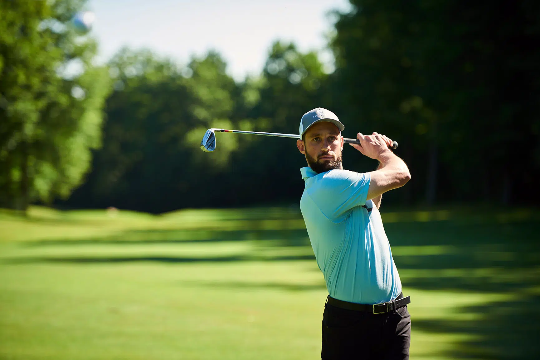 Golfer hits an iron down the fairway