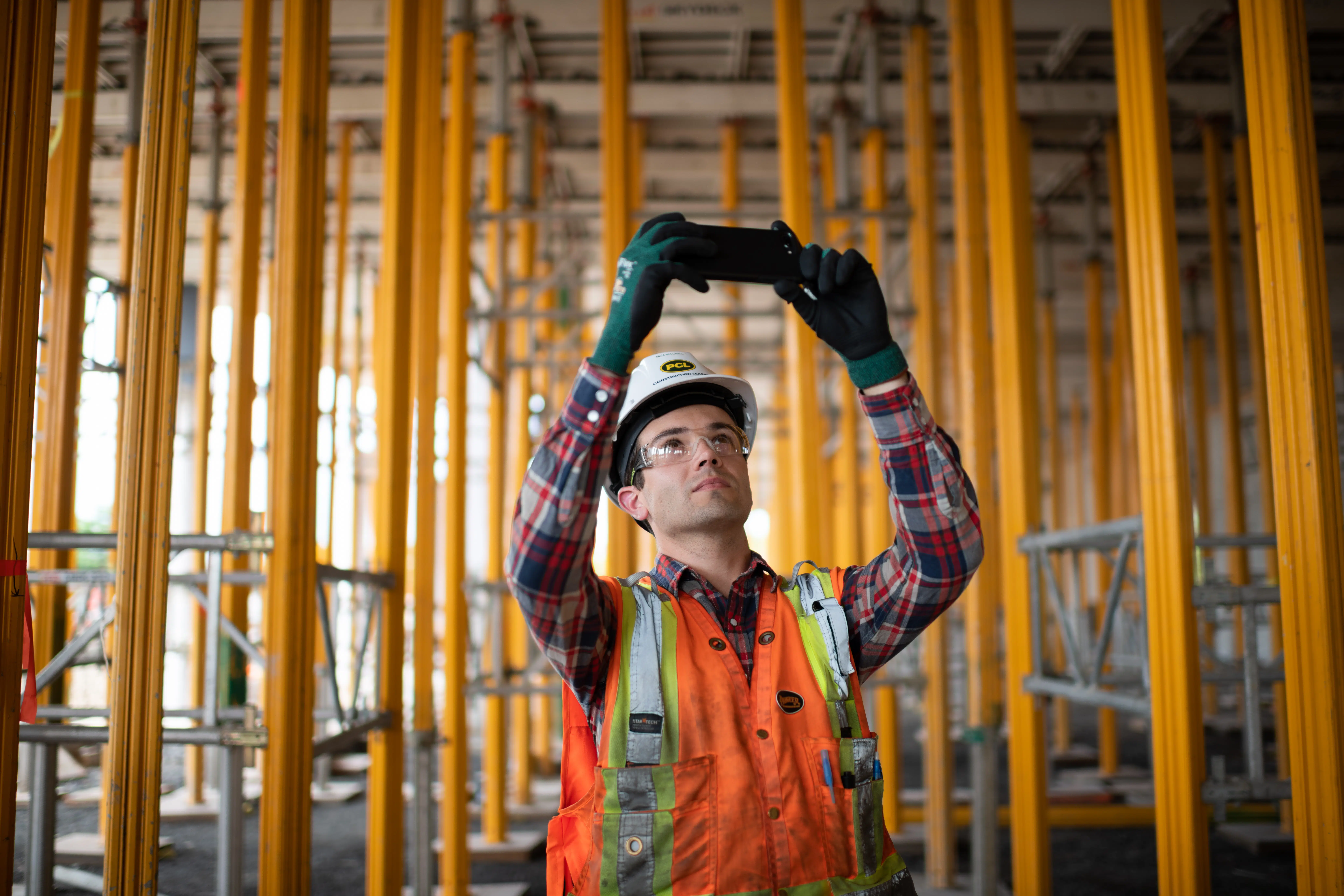A construction worker takes images of supports.