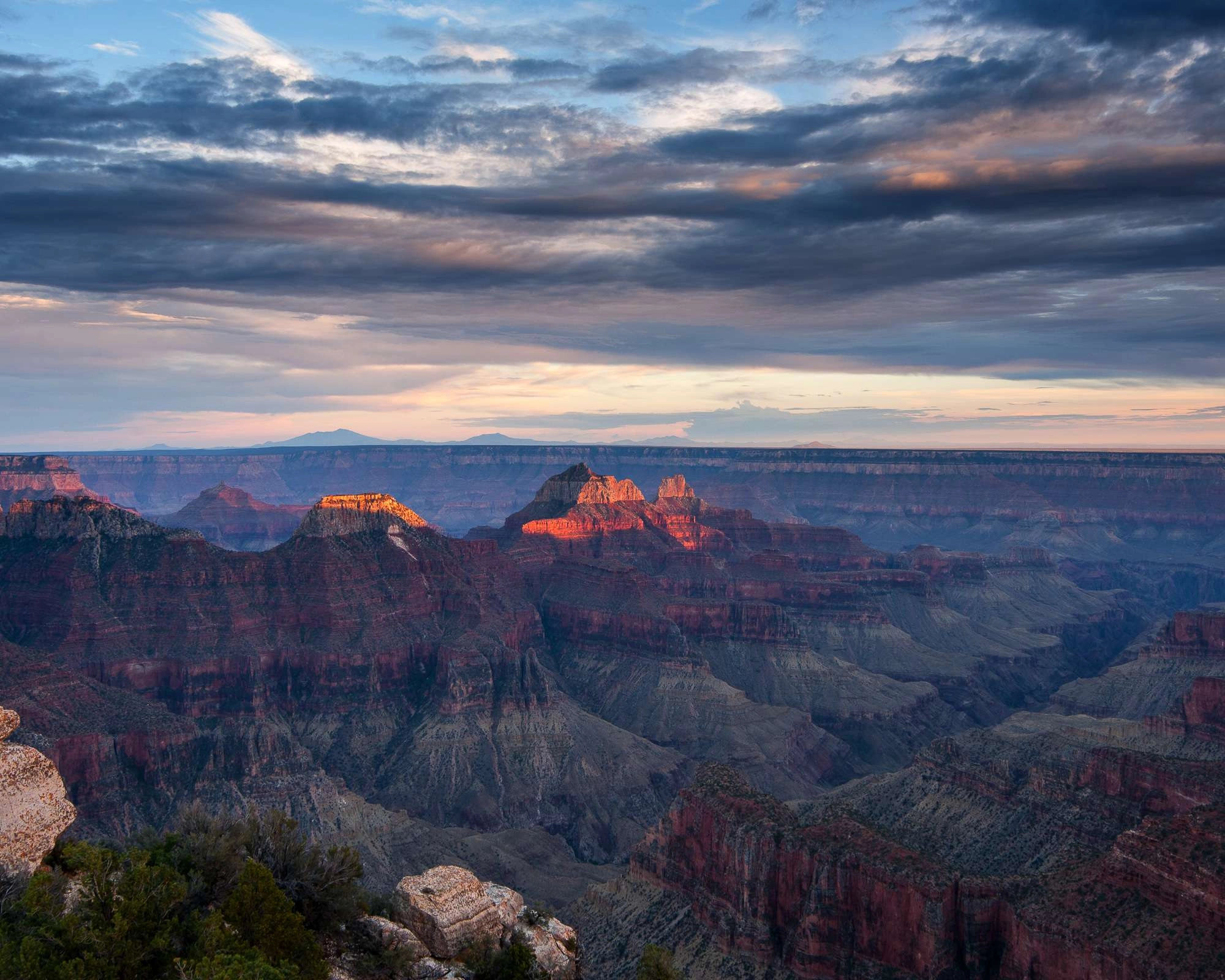 The sun sets across the north rim of the grand canyon.