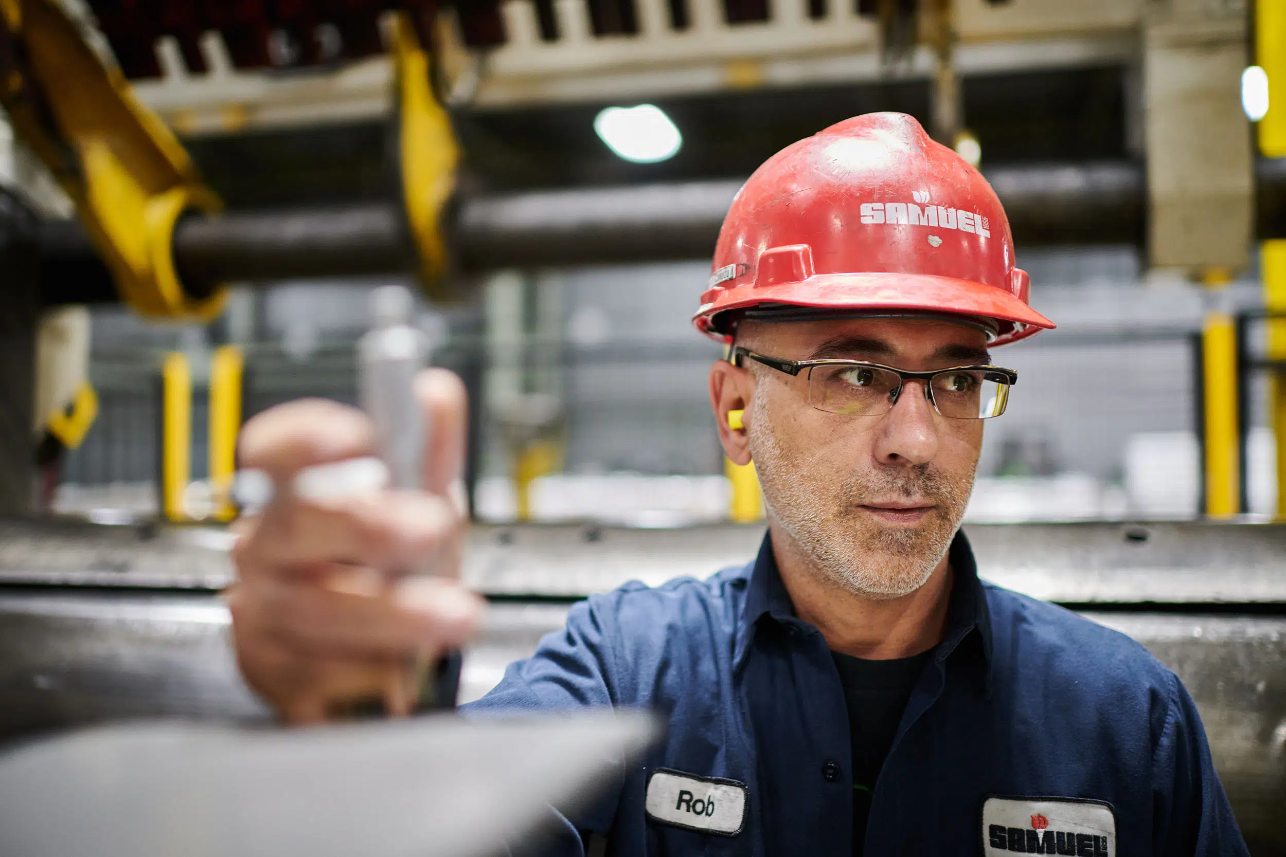 A worker checks the thickness of the steel.