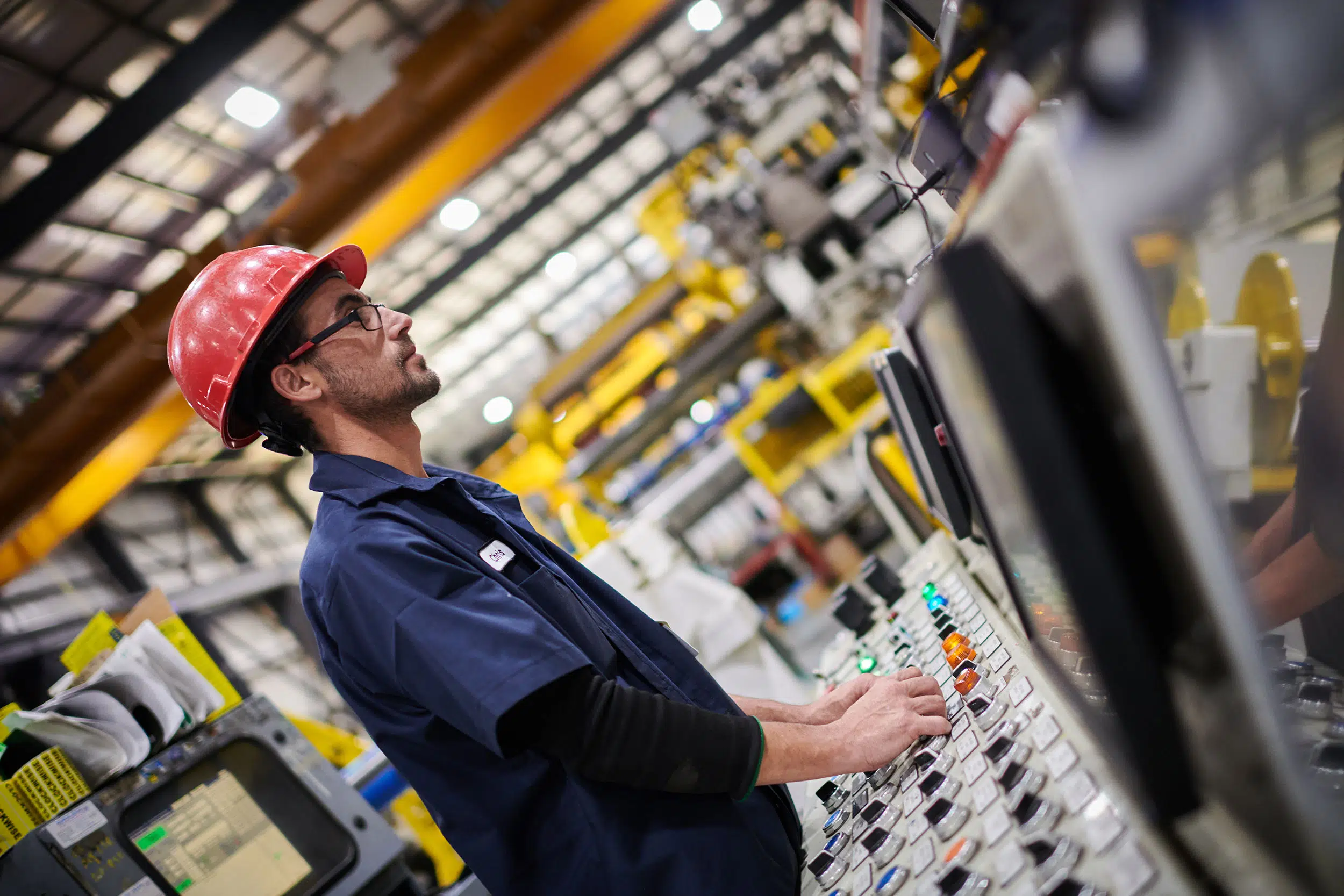 A worker operates a machine at a production facility.