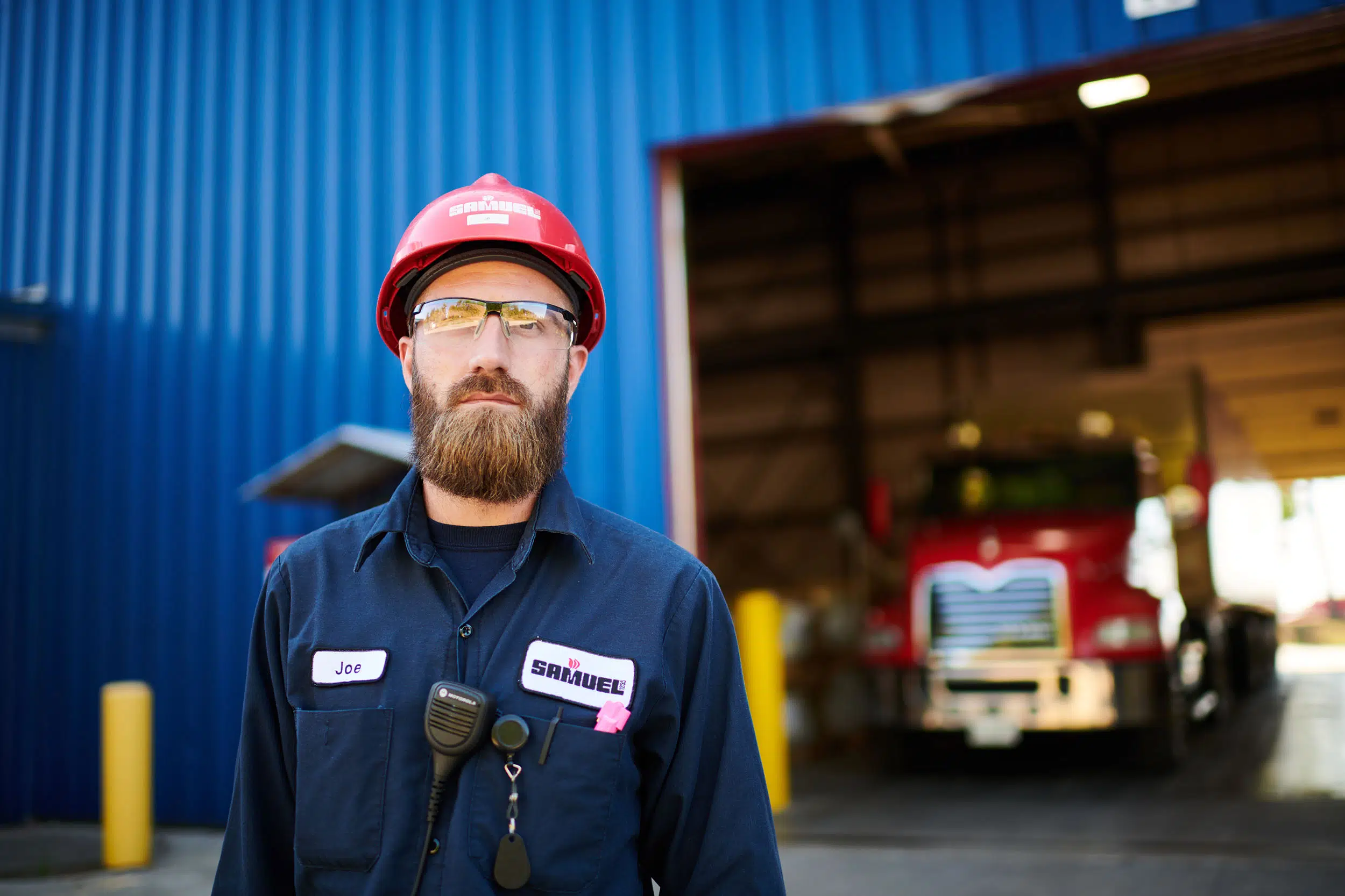 A worker stands outside a factory.
