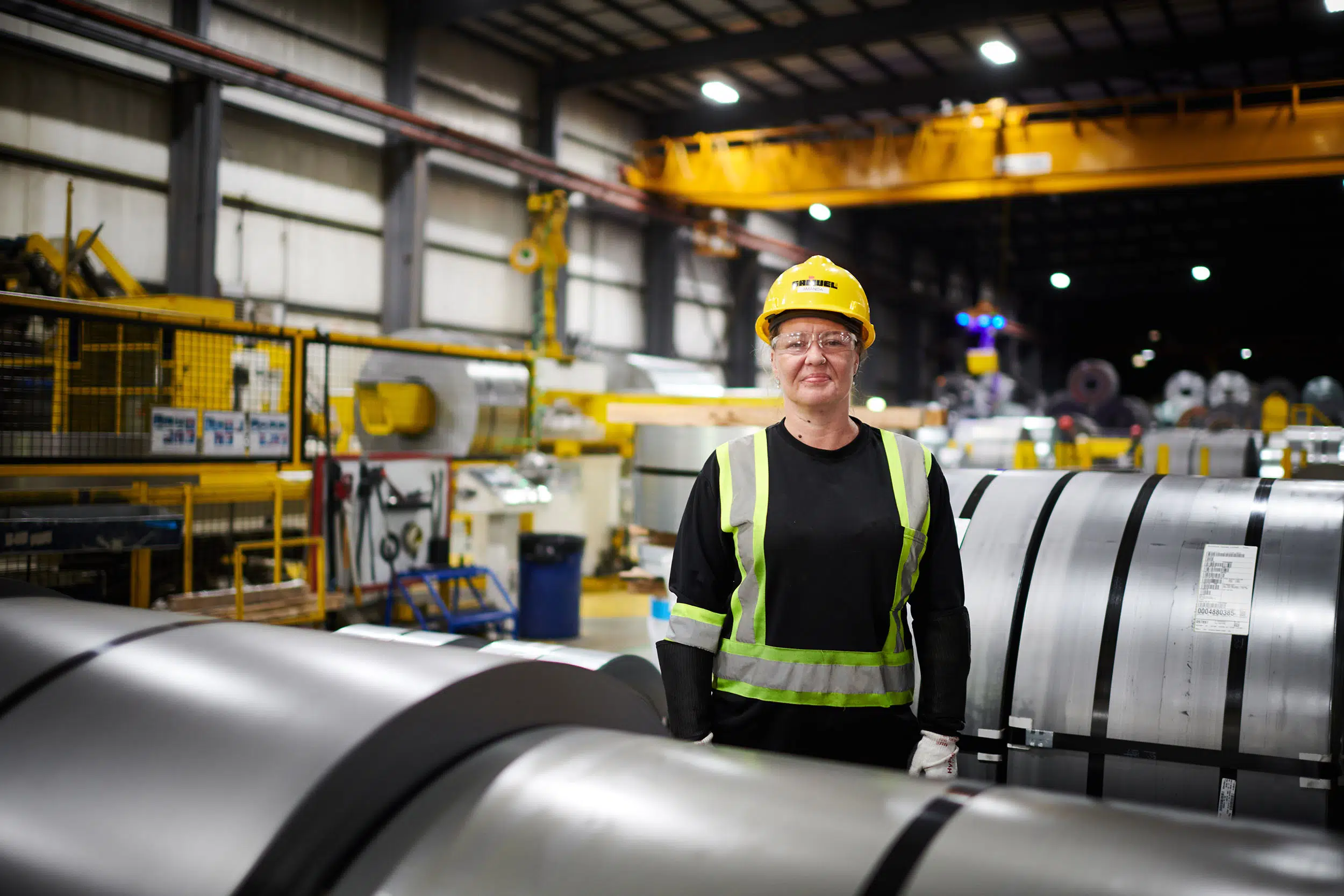 A female worker stands amongst the finished product.